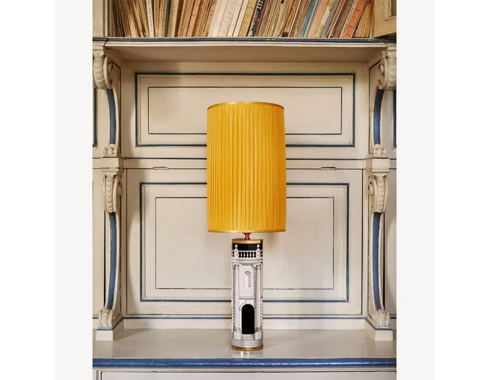 Elegant lamp featuring a detailed cylindrical base with architectural artwork and a striking yellow pleated shade, bringing warmth and sophistication to any setting.