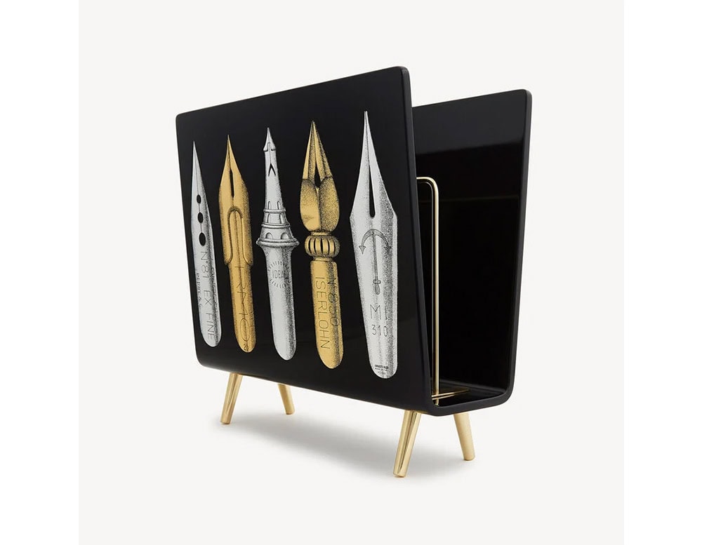 A striking black magazine rack featuring golden and silver pen nib illustrations, blending functional storage with playful artistic expression.