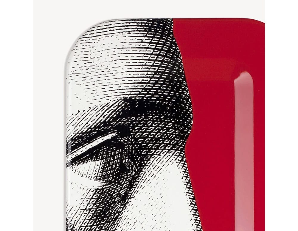 This striking tray captures a dramatic facial detail on a vivid red backdrop, creating a collectible design piece with practical appeal.