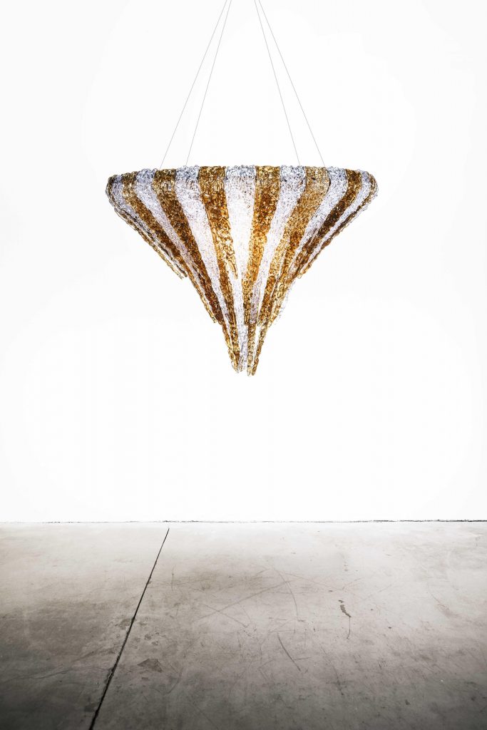 thick and colorful threads of methacrylic glass in the shape of an upside-down pyramid in white and golden color tone