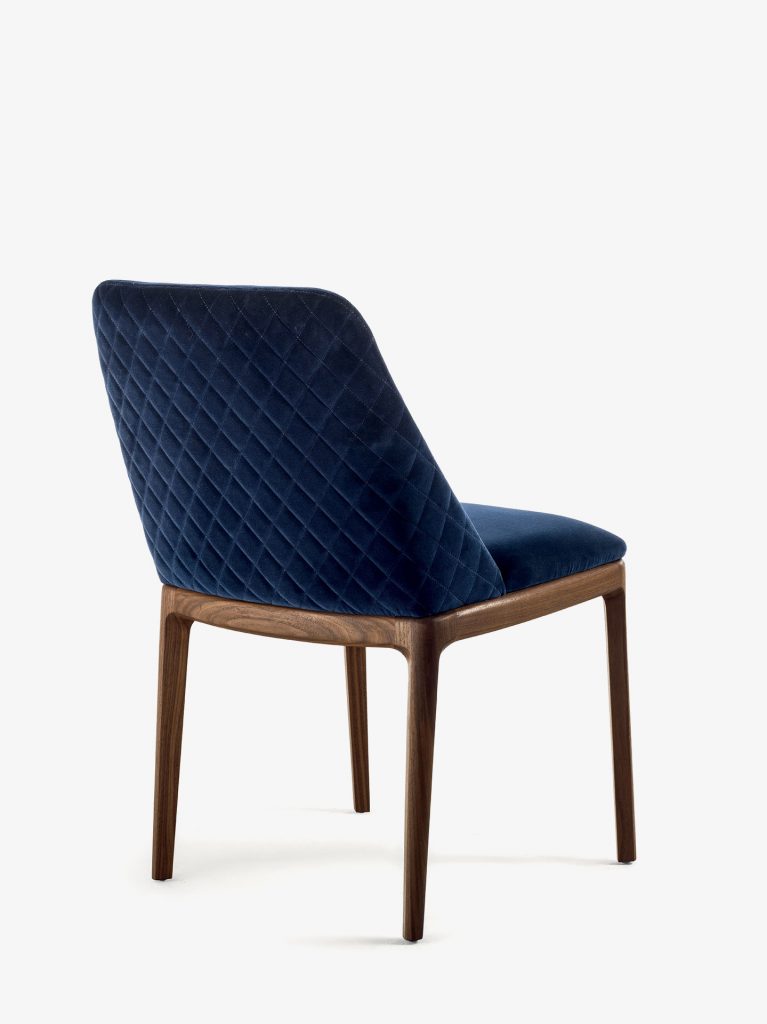chair made of smooth fabric in a dark blue tone resting on solid brown wooden legs