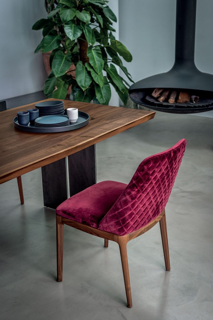 chair made of fabric with red stitching and a brown wooden base
