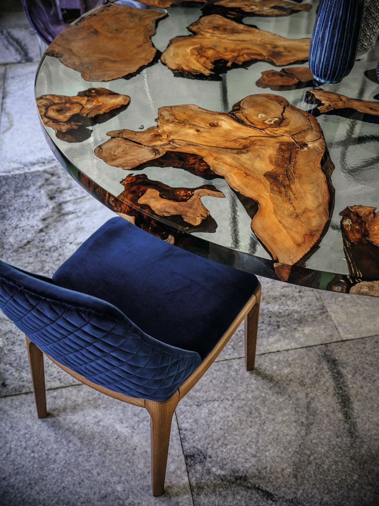 chair made of fabric with dark blue stitching and a brown wooden base