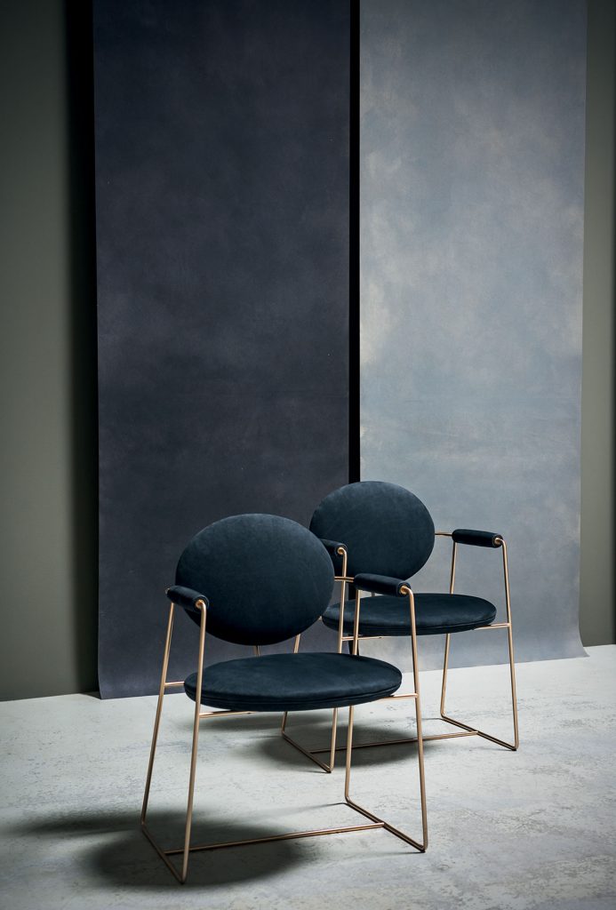 two dining chairs made in the shape of geometric figures in gray leather and stained metal base