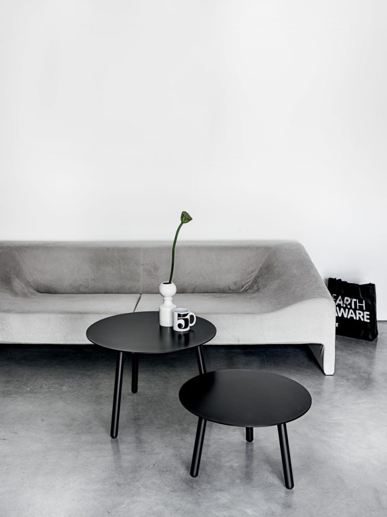 two small round wooden tables painted glossy black in a living room