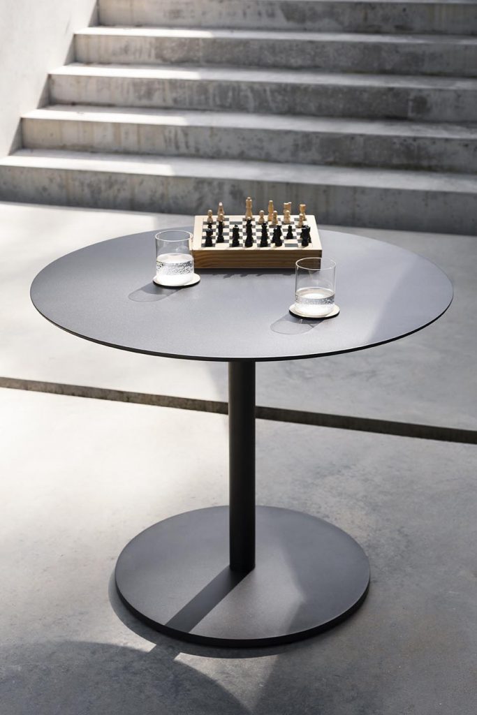 Button Two Table in front of a set of stairs and a chess board on top of the table