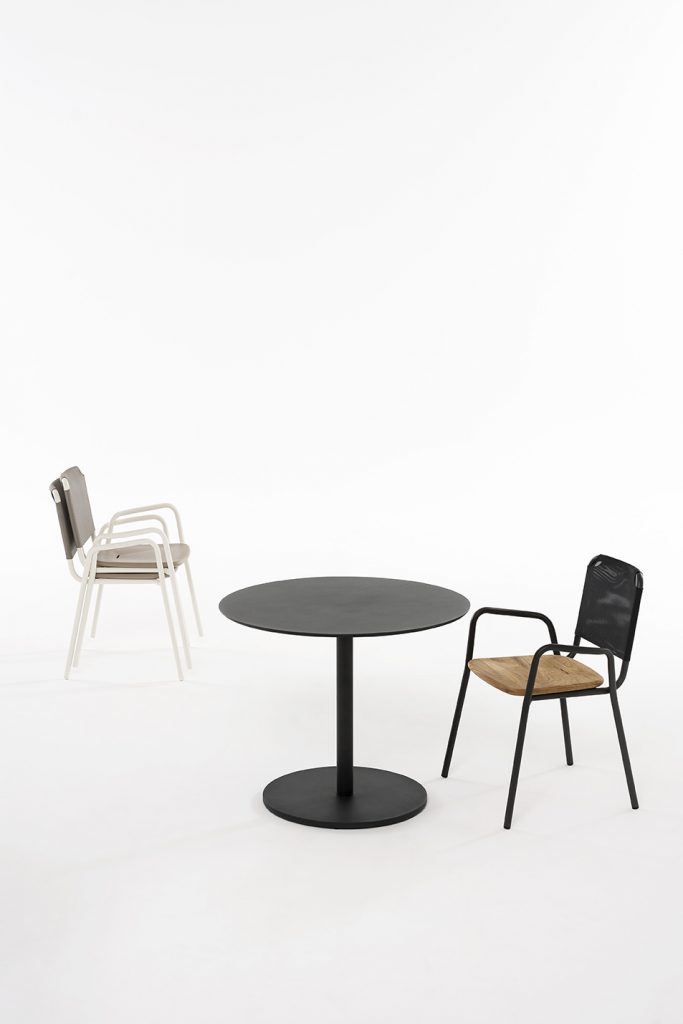 Button Two Table with a chair on either side in front of a white background