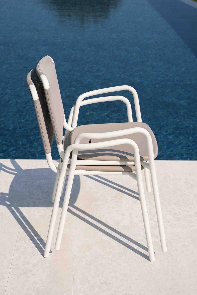 Two Guest One Armchair in white stacked on top of each other next to a pool