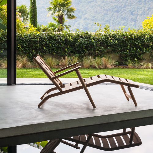 Levante Eight Chaise Longue next to a pool with a mountain in the background