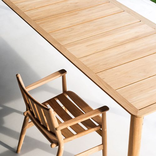 Levante Twenty-Two Table with a wooden chair next to the table