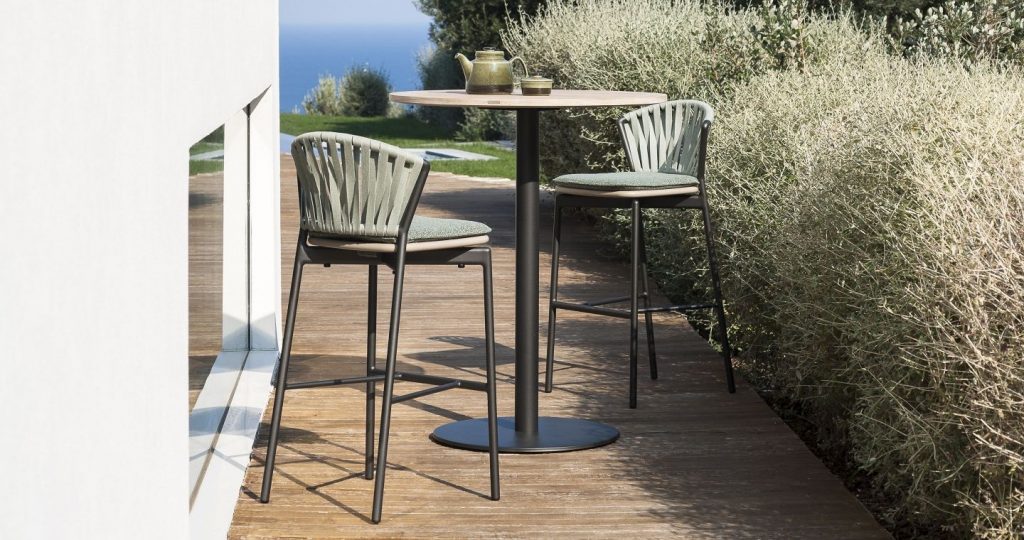Pair of Piper Bar Stool on two sides of a small round table outside on a patio