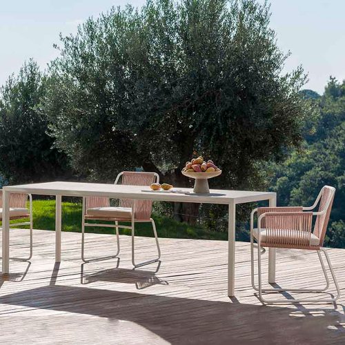 Plen Air Three Table with three chairs surrounding the table on a patio