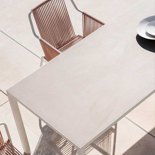 Top view of Plen Air Four Table with a chair next to the table on a patio