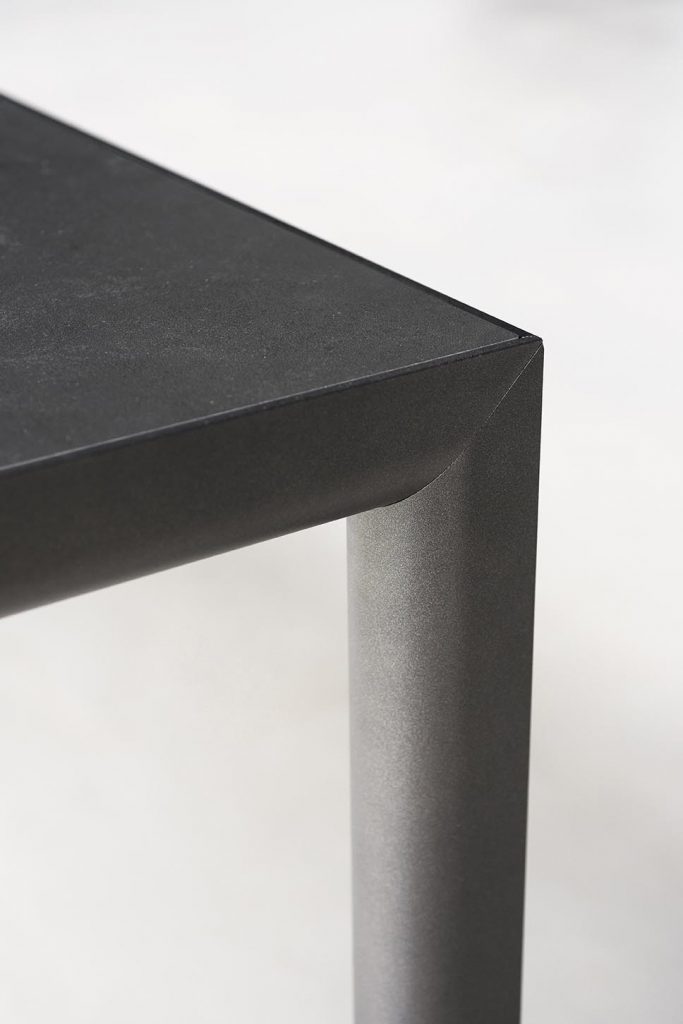 Close up of edge of Plen Air Table in black in front of a white background