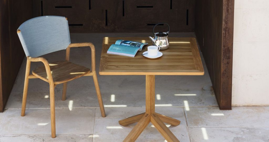 Root One Table with a chair at one side of the table on a white marble floor