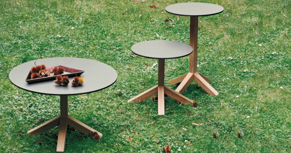 Root Forty Five Side Table on grass with two other tables in a line formation