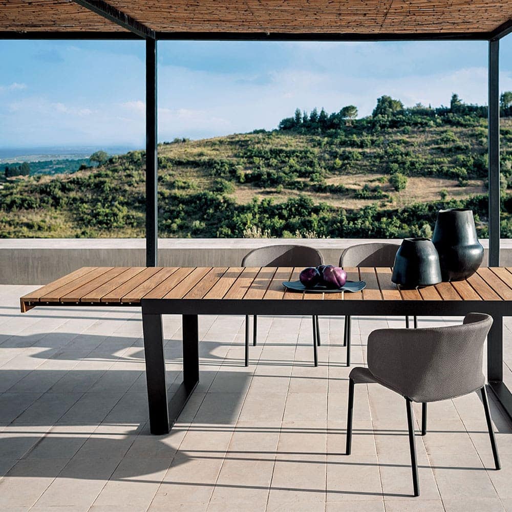 Spinnaker Thirty Four Extendable Table on a patio with a hill in the background