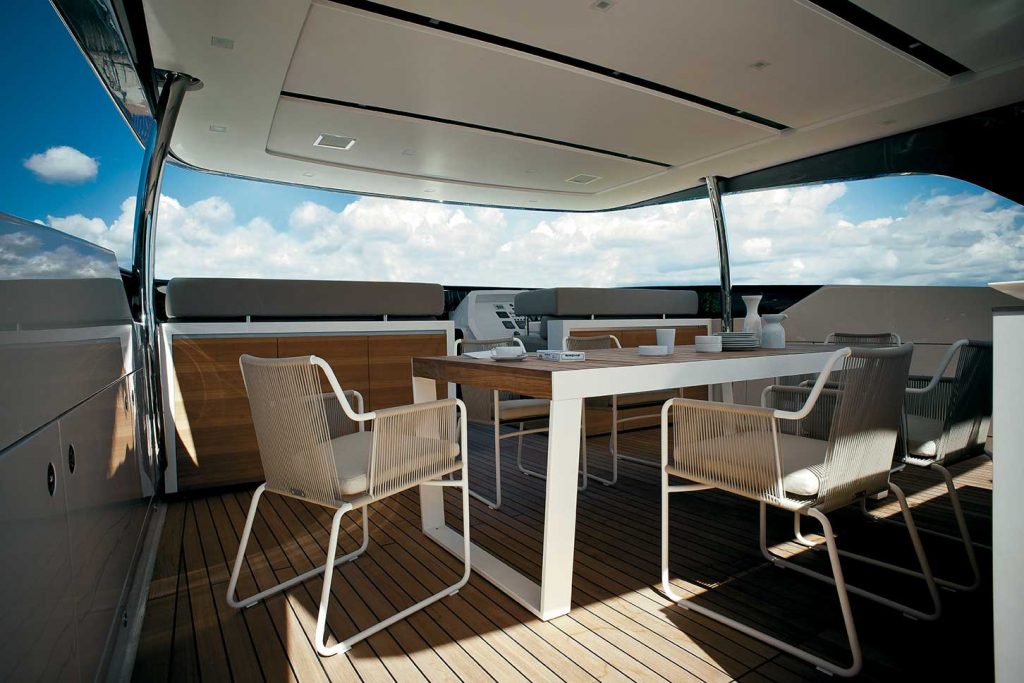 Spinnaker Thirty Four Extendable Table shown on a yacht with some chairs surrounding the table