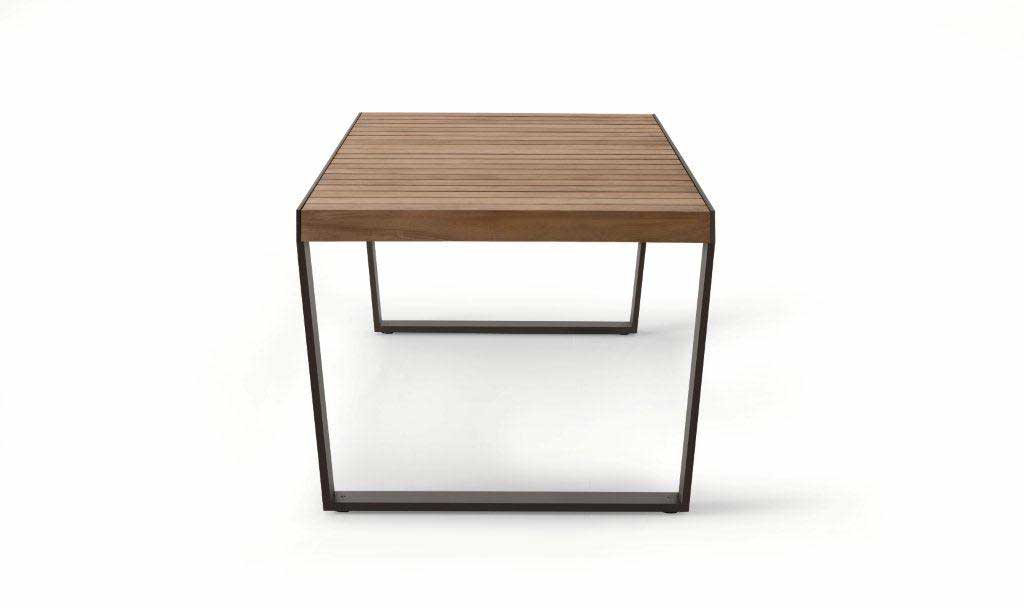Side view of Spinnaker Thirty Four Extendable Table in a dark wood finish in front of a white background