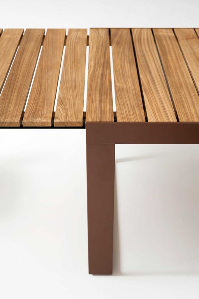Close up of the top of Spinnaker Thirty Four Extendable Table showing the light wood slates in front of a white background
