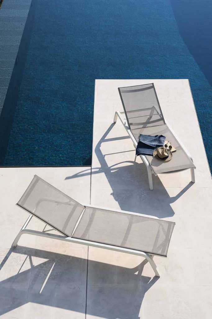 Two Surfer One Sunlounger in grey next to a pool