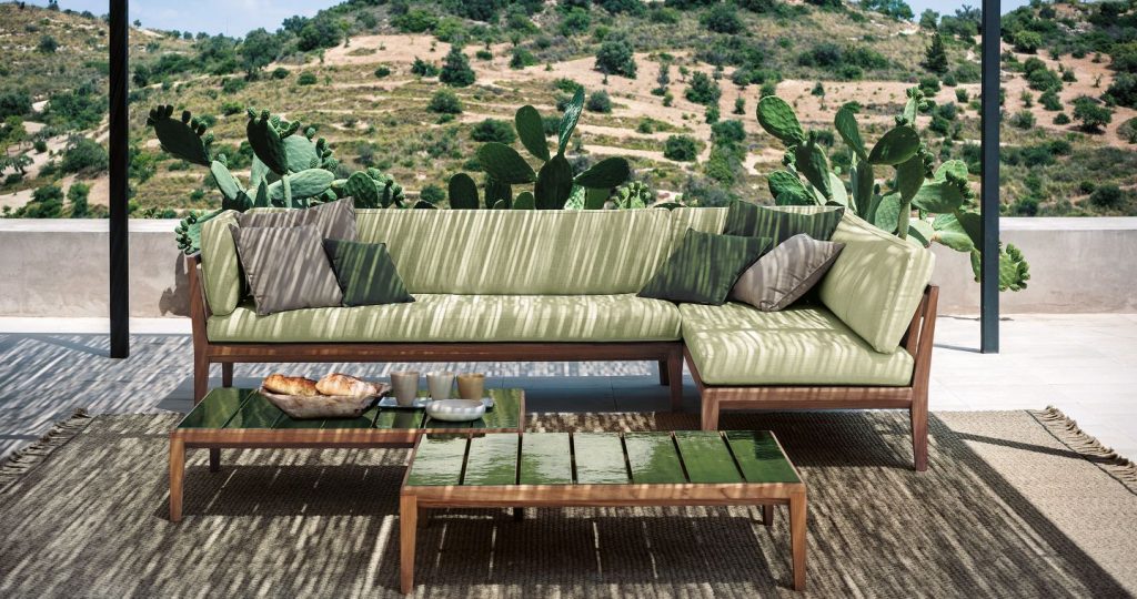 Teka Nine Coffee Table in front of an outdoor sofa with hills in the background