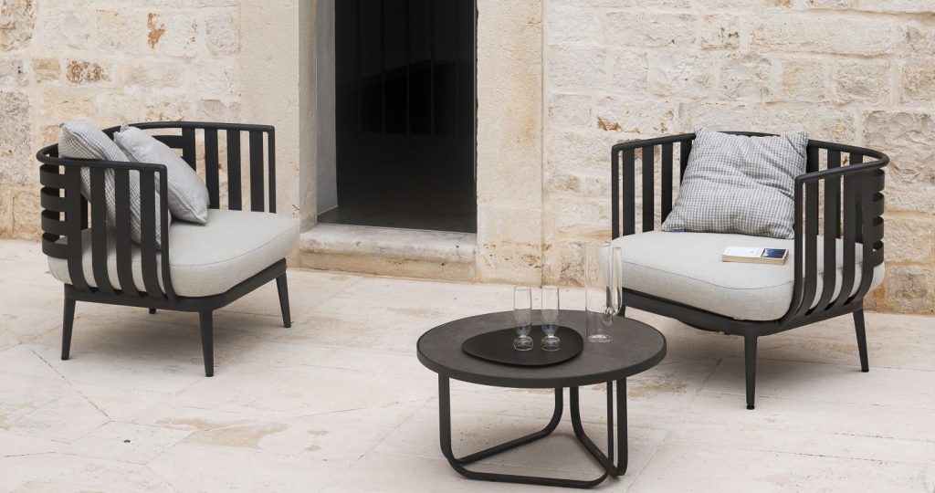 Thea Nine Coffee Table in front of two armchairs on a patio