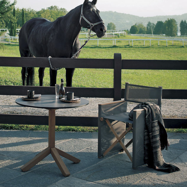 Root Three Bistro Table outdoor table next to an outdoor chair and a living horse in the background