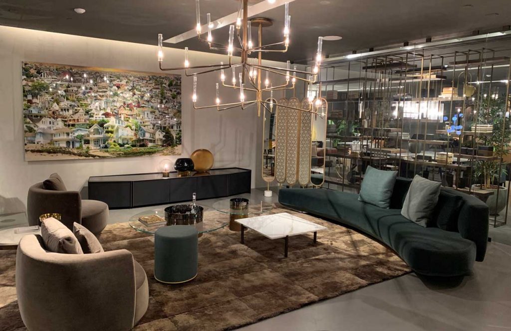 Tatiana large area rug with a sofa, armchair, and coffee table on top and a chandelier hanging overhead