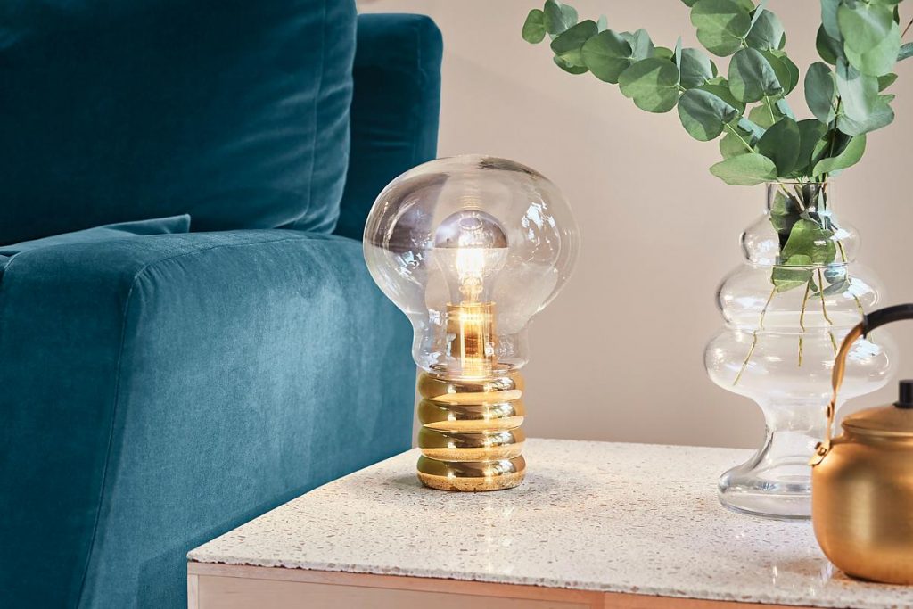 Bulb Brass on a table next to a blue couch