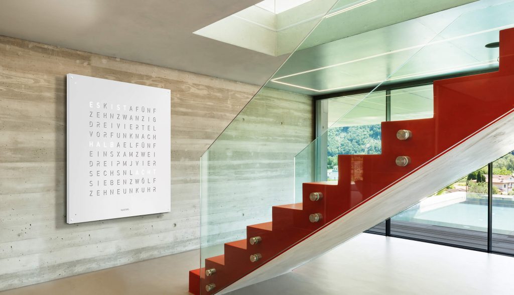 QLOCKTWO One Hundred Eighty in white in front of a red colored steps staircase