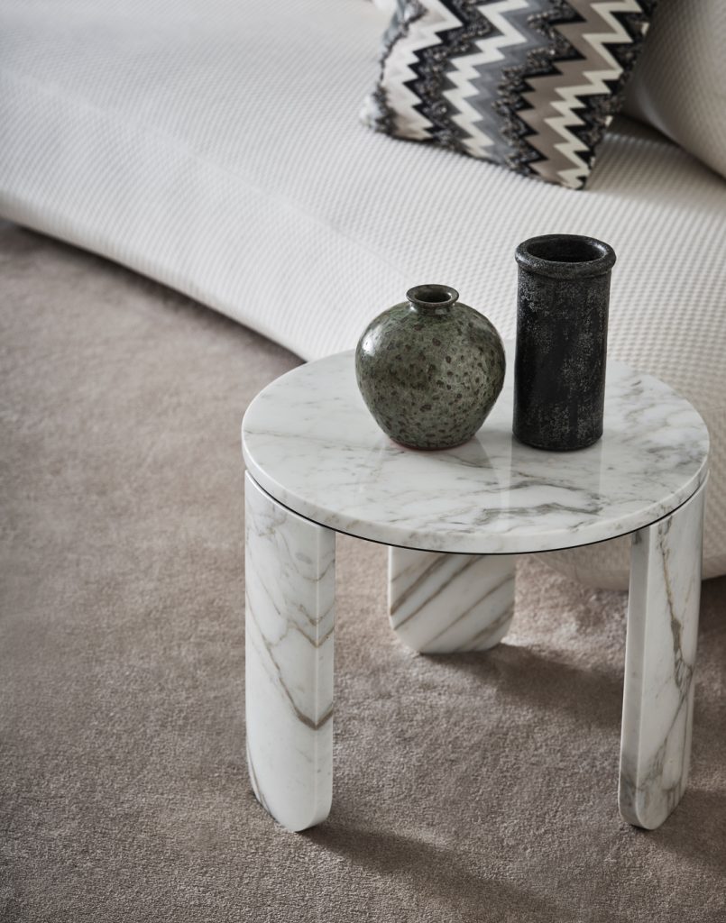 Audrey XS sofa in white in the background of a small marbled table on a brown rug