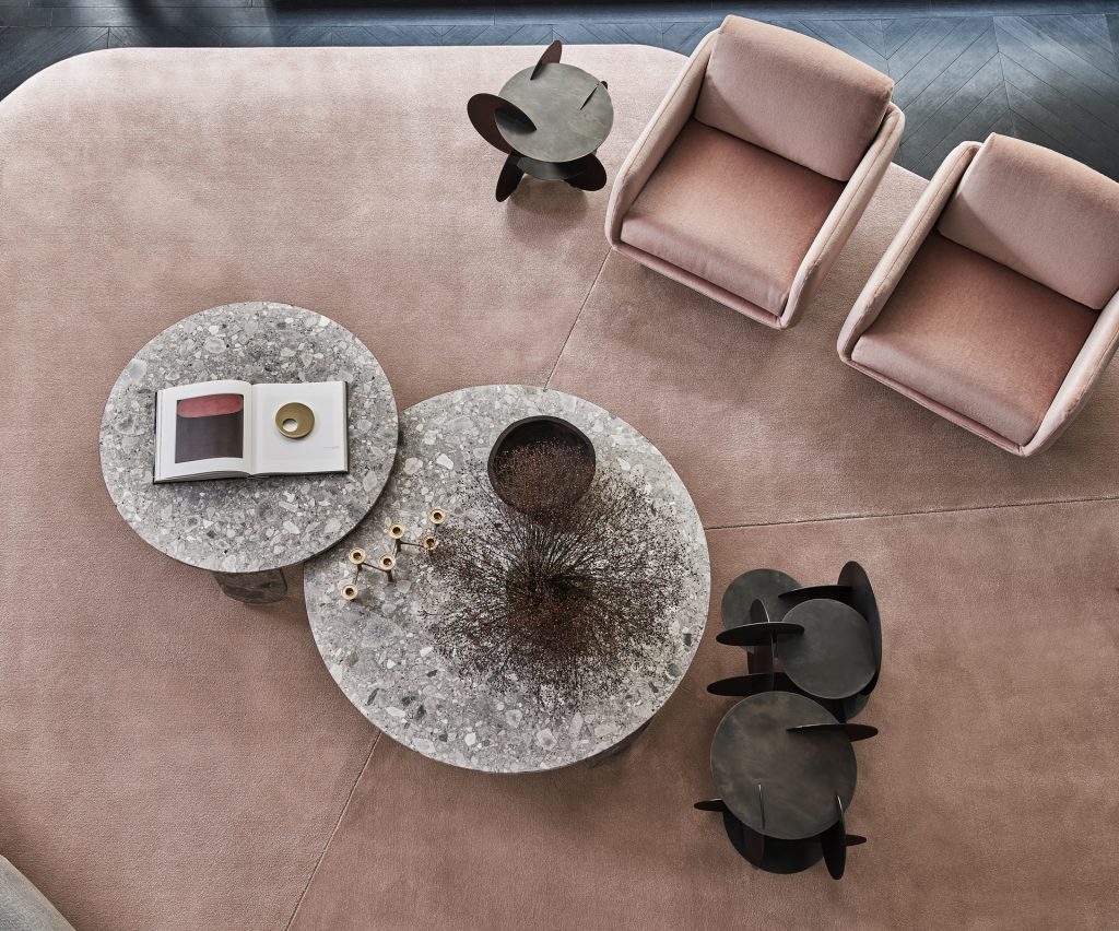 Close up top view of Resia rug with a pair of pink chairs and Monete coffee table next to a Clemo marble round table