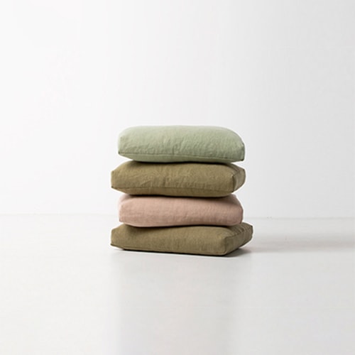 Cushions linen and hemp stacked on top of each other in front of a white background