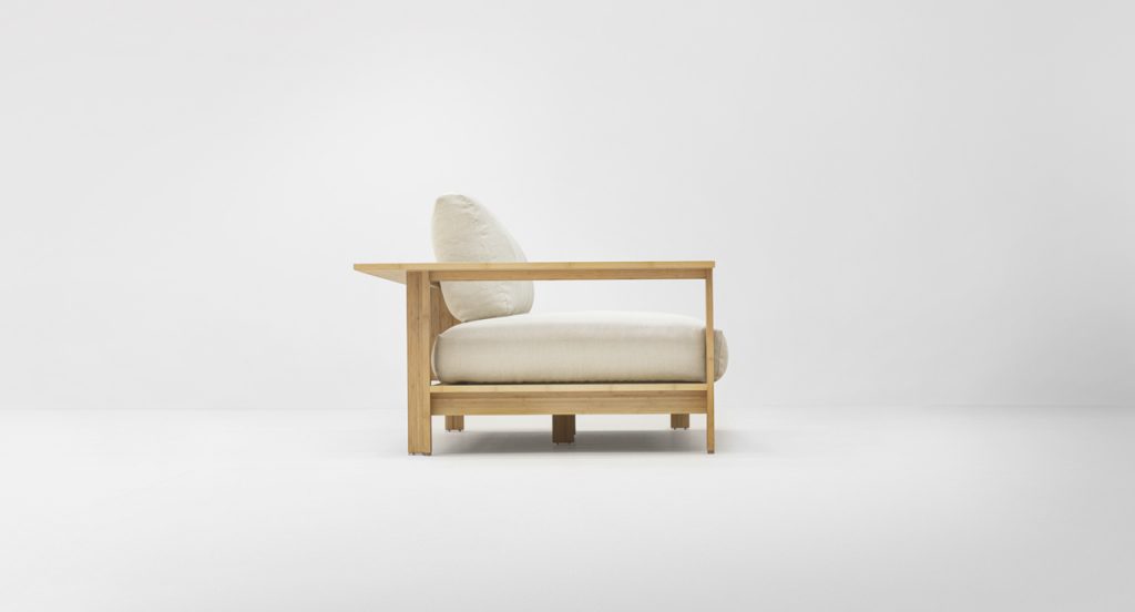Side view of Frei Sofa in a cream color in front of a white background
