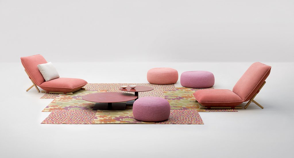 Pair of Hiro Lounge Chair with multicolored chairs in between them and a multicolored rug underneath the multicolored chairs