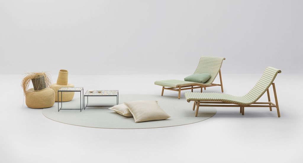 Pair of Shibusa Chaise Longue with a light green rug in front of them and a table on top of the rug