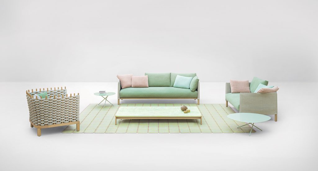 Vespucci Sofa in green with two arm chairs to the side and a green colored rug in front with a small green table on top