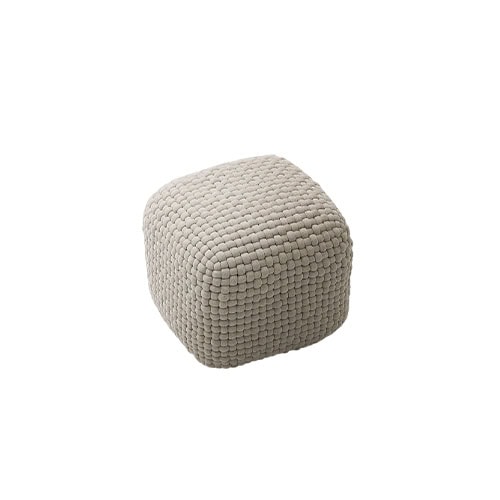 Compact ottoman in neutral beige with a soft square form, highlighted by its raised woven texture and cushioned appearance.