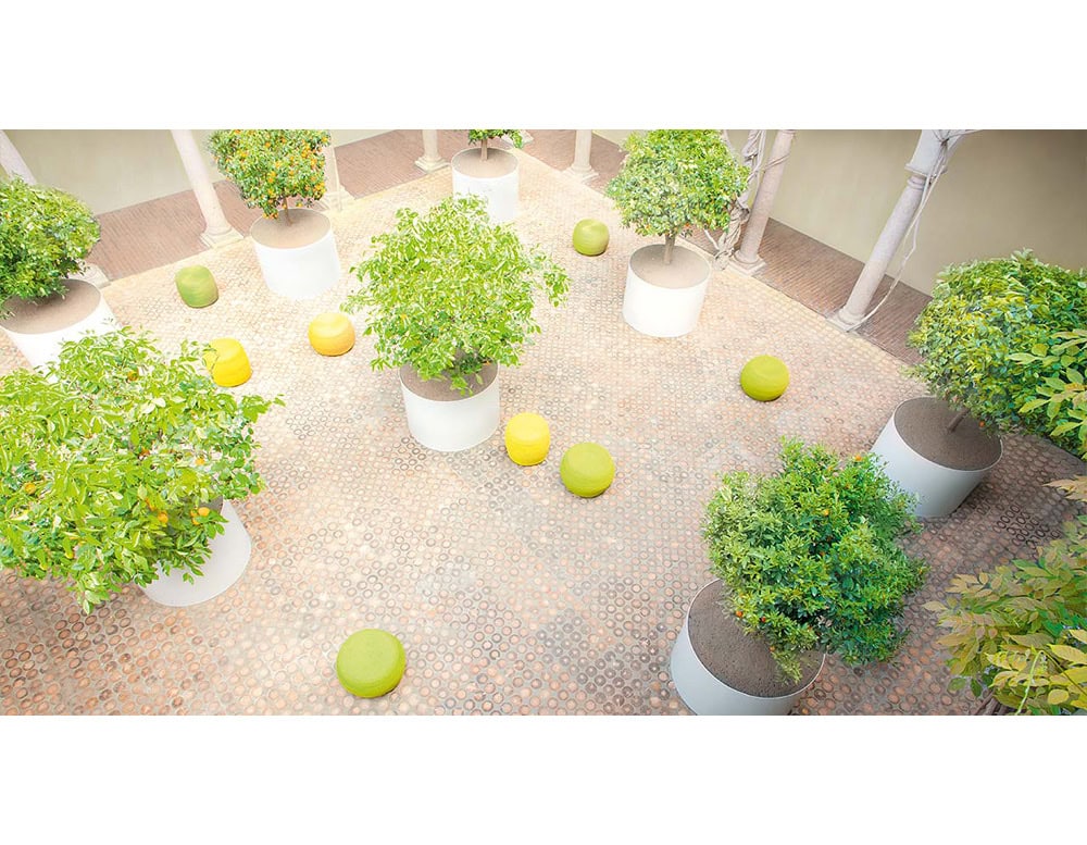 Bright poufs bring playful energy to this courtyard. Scattered among the planters, they invite casual seating while their bold green and yellow tones create a lively contrast with the natural setting.