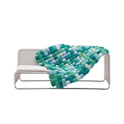 Contemporary bench accented with a handwoven blanket in cool tones, showcasing a geometric pattern that enhances comfort and visual interest.