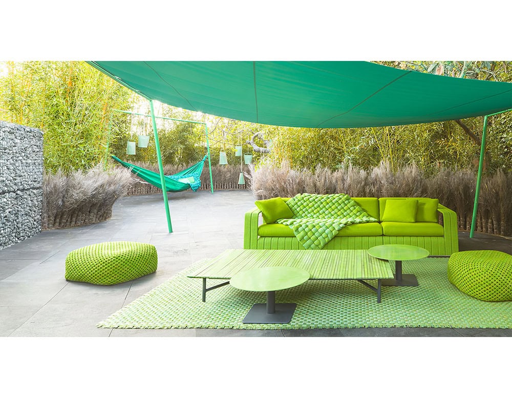 Striking outdoor sofa set in vivid green, paired with woven ottomans and sleek low tables. The bold color palette and textured details make it a standout for modern open-air living.