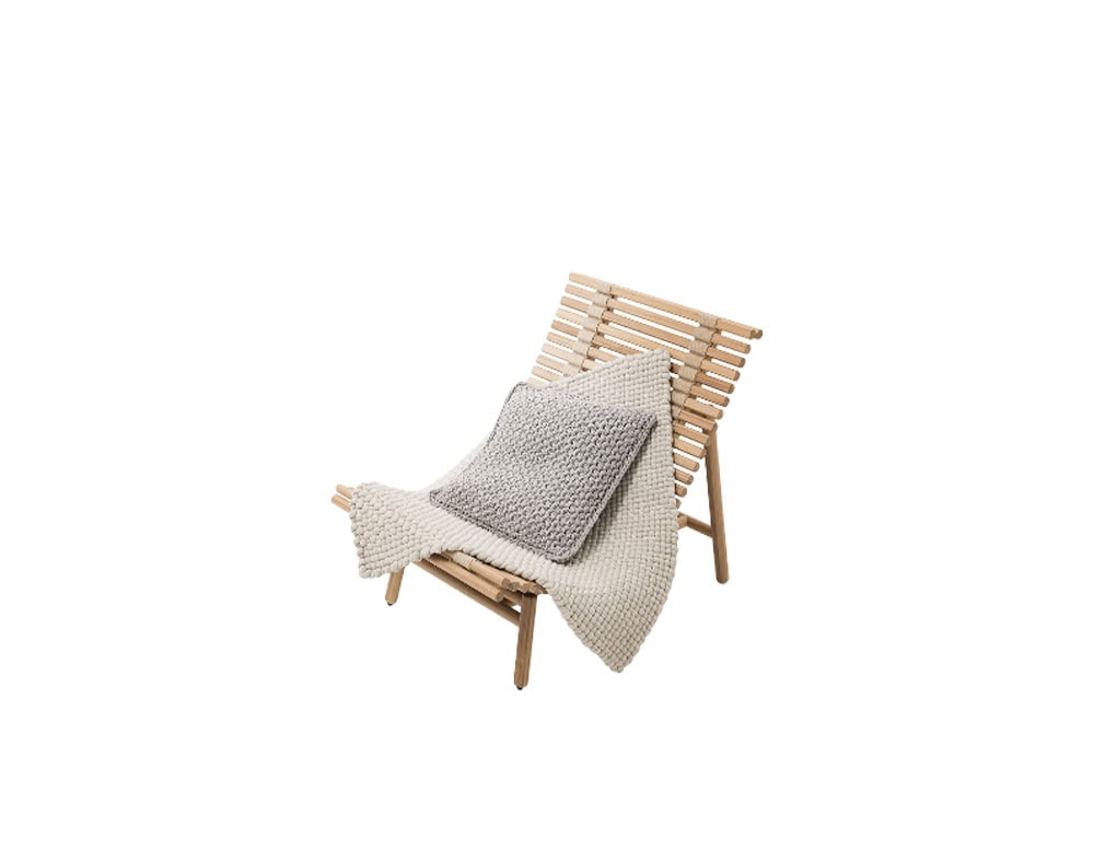 This armchair combines minimalist wood structure with soft knitted accents offering comfort and warmth while maintaining a refined modern aesthetic.