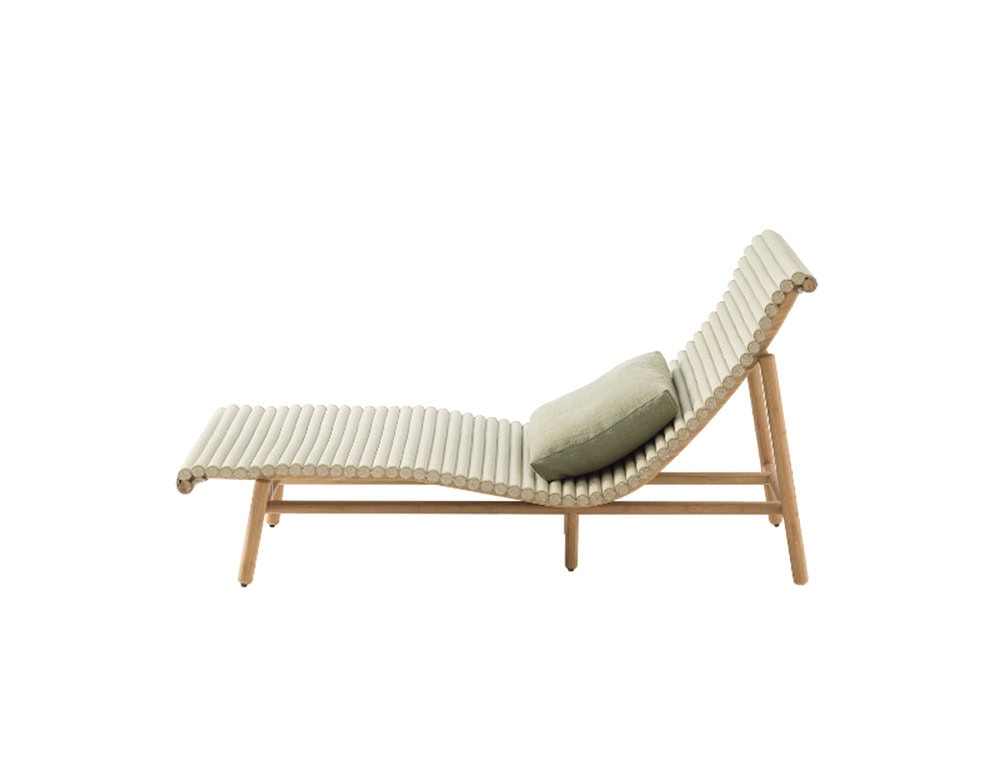 A sculptural lounge chair with a slatted wood frame and a gently curved silhouette, paired with a soft sage green cushion that enhances comfort and highlights its natural elegance.
