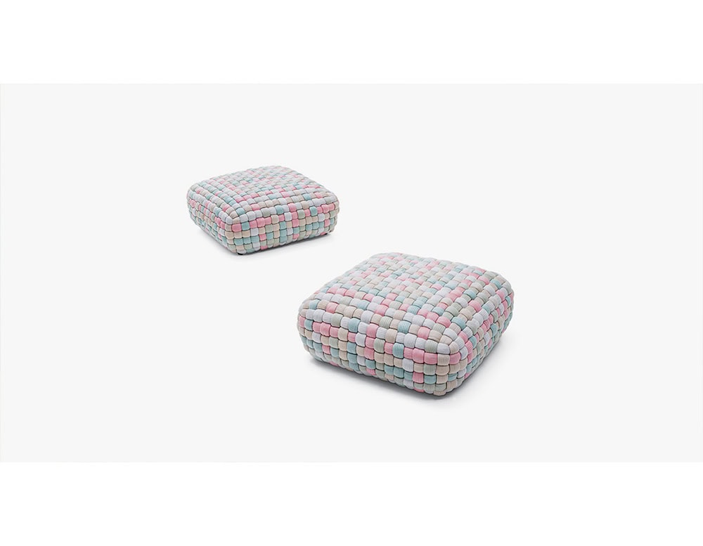 These poufs feature a handwoven design in soft pastel shades of pink, blue, and gray, offering a playful accent that doubles as extra seating or a casual footrest.