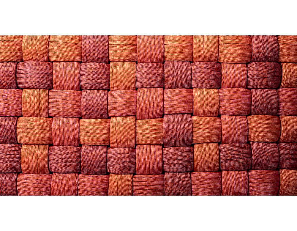 Interlaced strips in fiery shades of red and orange highlight the intricate weave, creating a dynamic surface that balances durability with visual warmth and artisanal design.