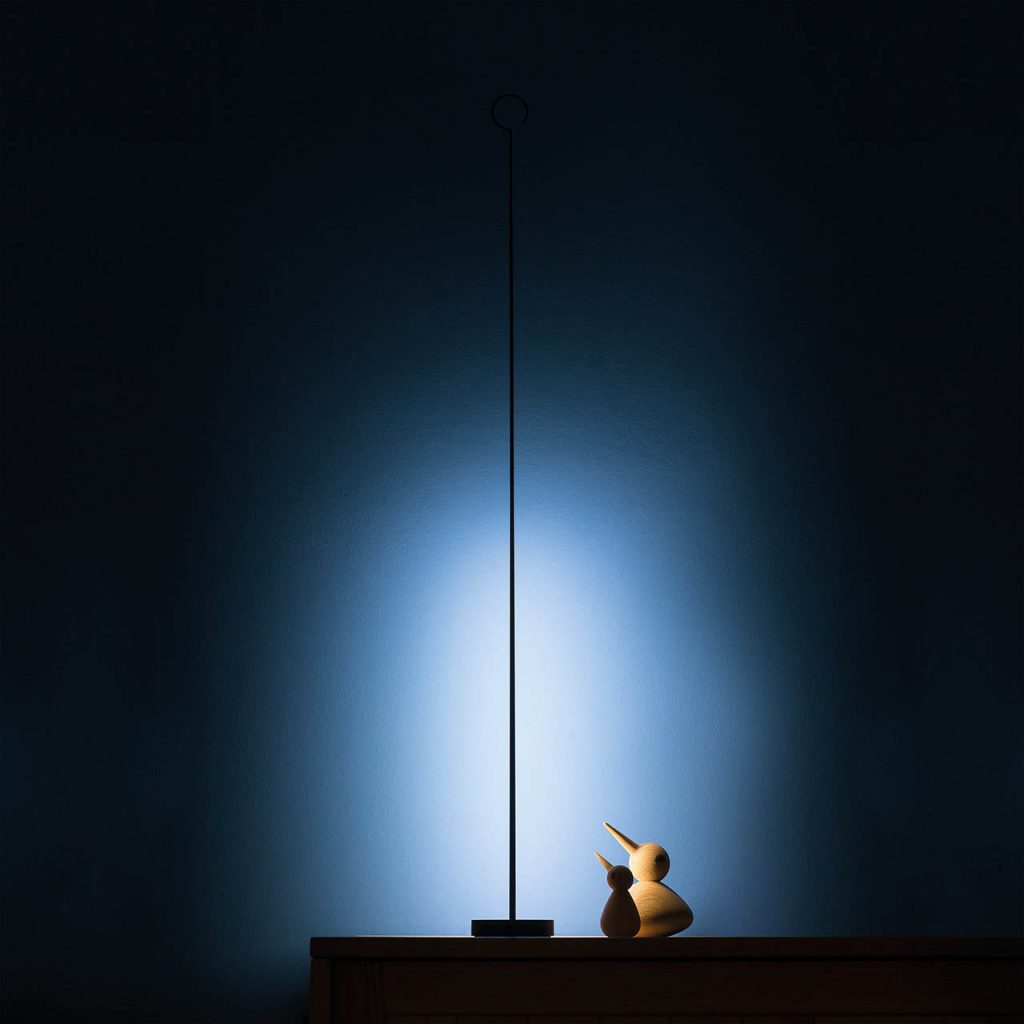 Anima light on a table shining against a blue wall in a dark room