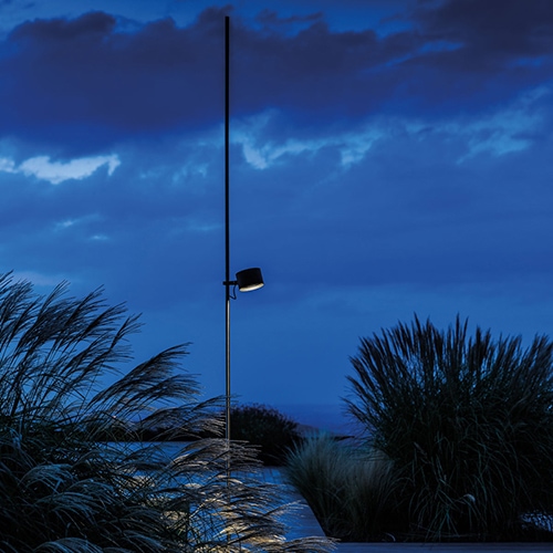 Bubka outdoor lamp in a desert setting with some plants on either side of the lamp