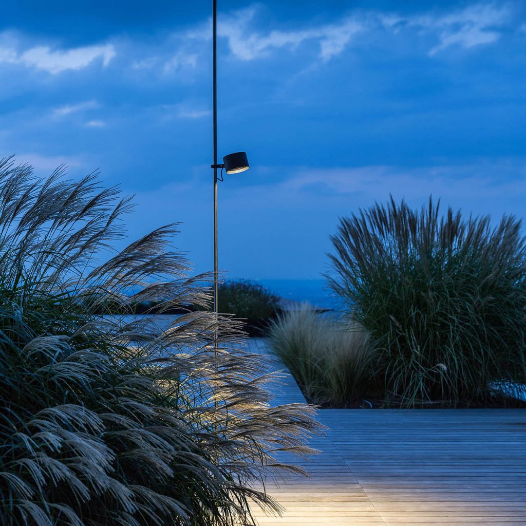 Bubka outdoor lamp in a desert setting with some plants on either side of the lamp