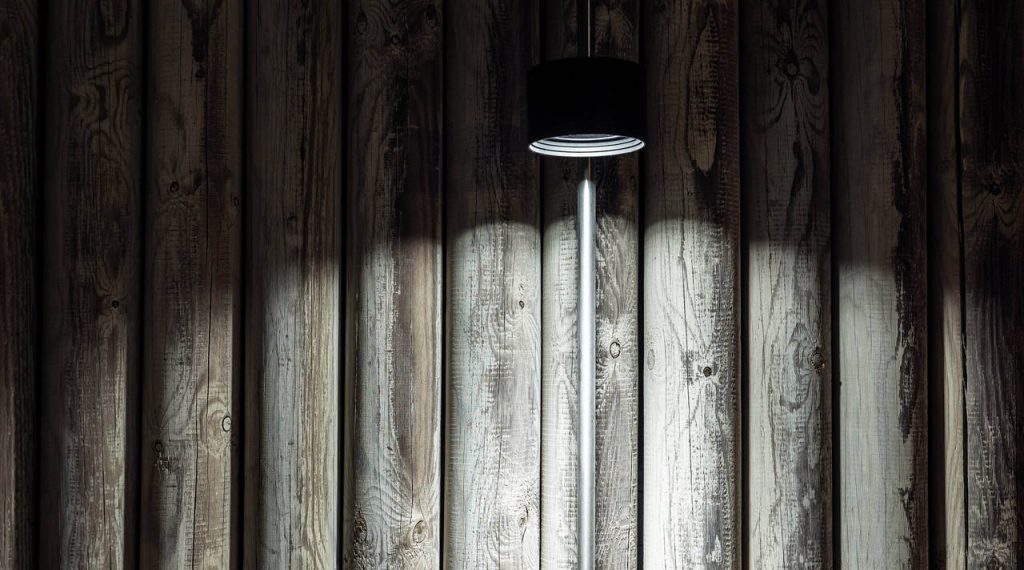 Bubka outdoor lamp against a wooden fence